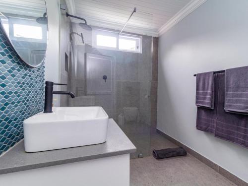 a bathroom with a white sink and a shower at 1 Harbour Way in Gansbaai