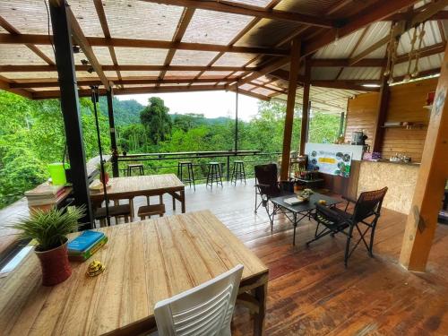 a living room with a wooden table and chairs at Amornkeeree Khao Sok Camping in Khao Sok