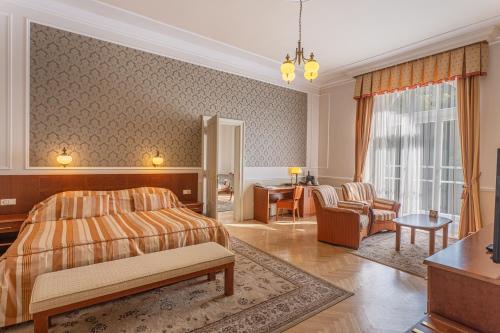 a bedroom with a bed and a living room at Hotel Radium Palace in Jáchymov