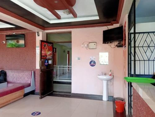 Habitación con sofá, lavabo y TV. en Hotel Manas Mtwapa Mombasa, en Mtwapa
