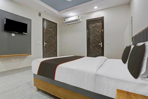 a bedroom with a bed and a flat screen tv at OYO Flagship 81411 Hotel Vip Grand in New Delhi