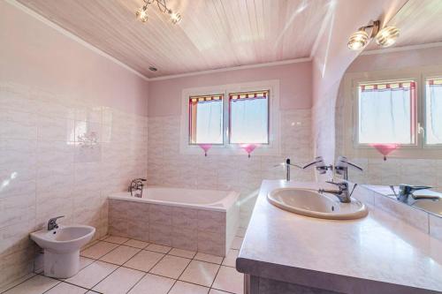 un bagno con due lavandini, una vasca e un WC di Le Cayroux - Clévacances 3 clés a Blanquefort-sur-Briolance