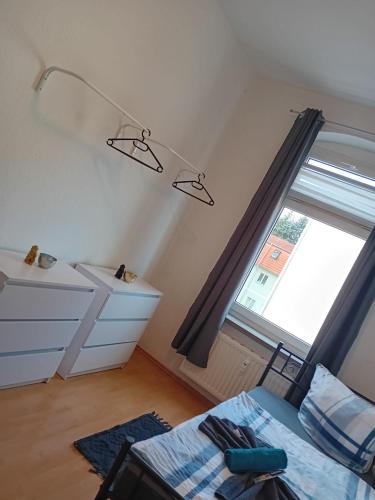 a bedroom with a bed and a window and a lamp at Stellas Monteurwohnungen in Werdau