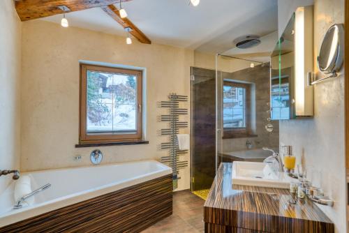 a bathroom with a tub and a sink and a shower at Appartement Hofmann in Königsleiten