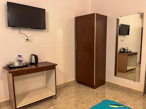 a room with a tv and a desk with a mirror at Arzu Homes in Anjuna