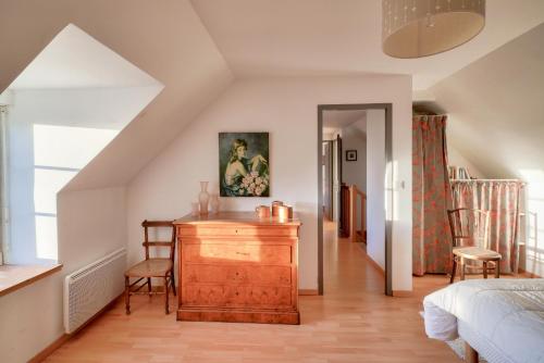 une chambre avec un lit et une commode en bois dans l'établissement Maison face à l'océan avec vue mer à Penmarc'h, à Penmarcʼh