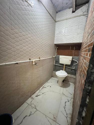 ブリンダーバンにあるShyam Sadan Guest Houseのトイレ付きの汚れたバスルームが備わります。