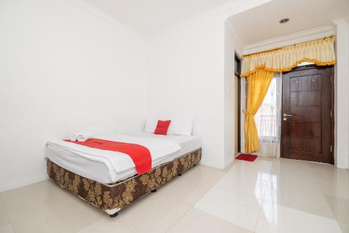 a bedroom with a bed and a window at RedDoorz at Gunungsari Surabaya 2 in Surabaya