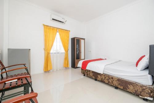 a bedroom with a bed and a window at RedDoorz at Gunungsari Surabaya 2 in Surabaya