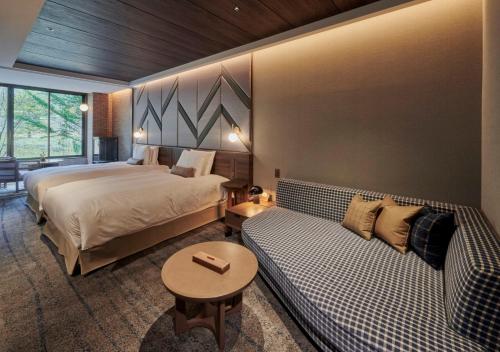 a hotel room with two beds and a couch at Fufu Kyu-Karuizawa Seiyou No Mori in Karuizawa