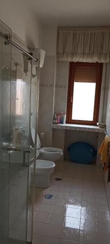 a bathroom with a toilet and a shower and a window at avellino camera centrale in Avellino