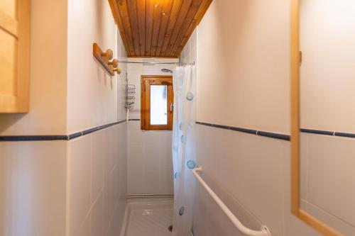 baño con paredes blancas y techo de madera en La Cordée des Angles - Studio mezzanine, en Les Angles
