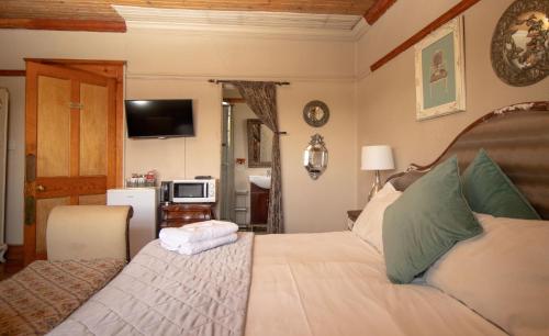 a bedroom with a bed and a television in it at Pandora's guesthouse in Bethlehem
