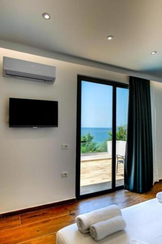 a bedroom with a flat screen tv and a bed at Hotel Emblem in Sarandë
