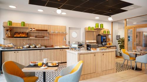 a kitchen with wooden cabinets and a table and chairs at Residhome Sénart in Lieusaint