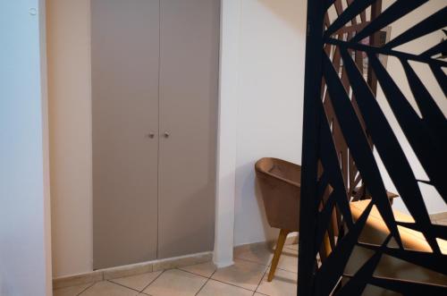 a room with white cabinets and a chair and a staircase at Unique studio at Athens Riviera 1 min from the sea in Athens