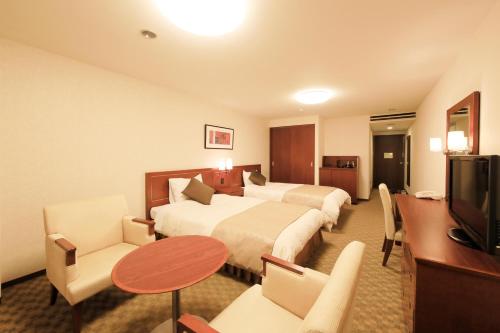 a hotel room with two beds and a table at FOURTREAT plus NASUKOGEN in Nasu