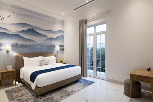 a bedroom with a large bed and a large window at The Grand Mansion Menteng by The Crest Collection in Jakarta