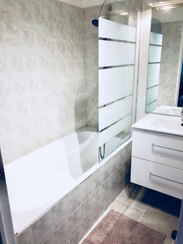 une salle de bain avec une douche, un lavabo et une baignoire dans l'établissement Le Gentil Paris, à Gentilly