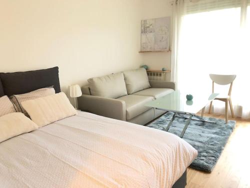 une chambre avec un grand lit et un canapé dans l'établissement Le Gentil Paris, à Gentilly