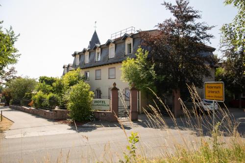 a large white house with a sign in front of it at Hotel Villa Magnolia in Rödermark