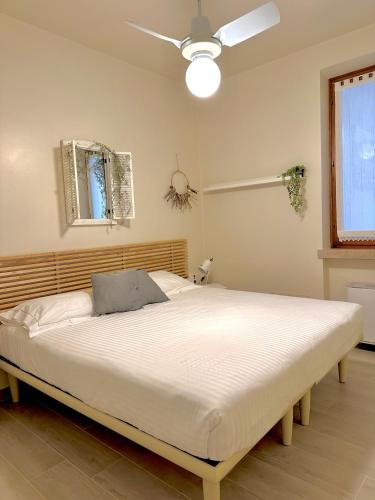 a bedroom with a large bed with a ceiling fan at Lauri & Faggi in Desenzano del Garda