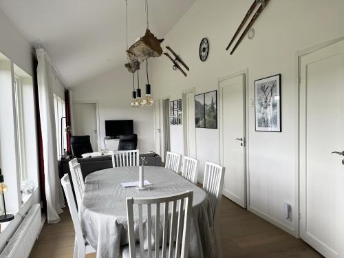 comedor con mesa y sillas blancas en Mountain cabin with a magically beautiful view in Husa near Are en Järpen