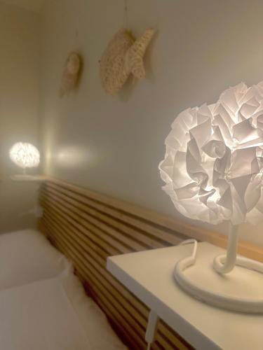 a white lamp on a table next to a bed at Lauri & Faggi in Desenzano del Garda