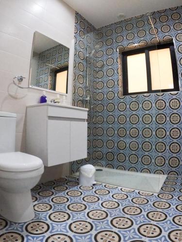 a bathroom with a toilet and a sink and a mirror at Sun Sea Living Gozo (Seagull) in Xlendi