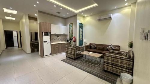 ein Wohnzimmer mit einem Sofa und einem Tisch sowie eine Küche in der Unterkunft خيالى2 in Chamis Muschait