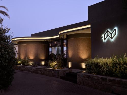 a building with a sign on the side of it at Acro Suites - A Wellbeing Resort in Agia Pelagia