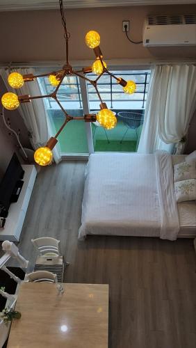 a bedroom with a white bed and a window at Pension Haneul Tari in Jeju