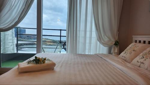 a bedroom with a bed with a large window at Pension Haneul Tari in Jeju