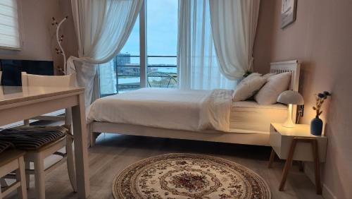 a bedroom with a bed and a large window at Pension Haneul Tari in Jeju