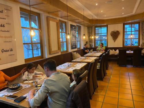a group of people sitting at tables in a restaurant at Hotel in the HEART of the Alps in Uttendorf