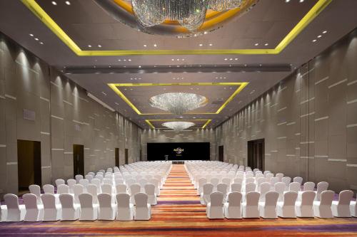 an empty hall with white chairs and a stage at Hard Rock Hotel Shenzhen in Shenzhen