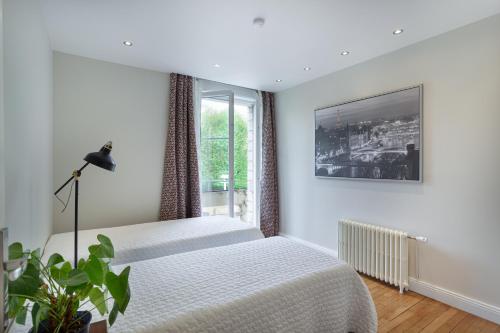 a bedroom with two beds and a window at Les appartements de Chantilly - gare in Chantilly