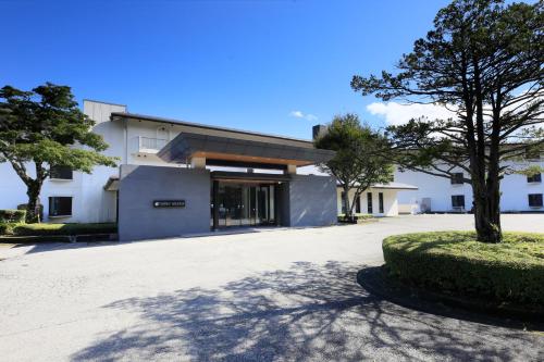 a white building with a tree in front of it at FOURTREAT plus NASUKOGEN in Nasu