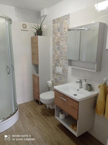a bathroom with a sink and a shower and a toilet at Apartman Linda in Krk
