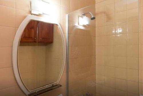 La salle de bains est pourvue d'une douche et d'un grand miroir. dans l'établissement 2 Departamento pleno Centro todo equipado, à Córdoba