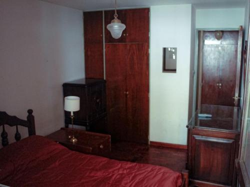 - une chambre avec un lit rouge et une commode dans l'établissement 2 Departamento pleno Centro todo equipado, à Córdoba