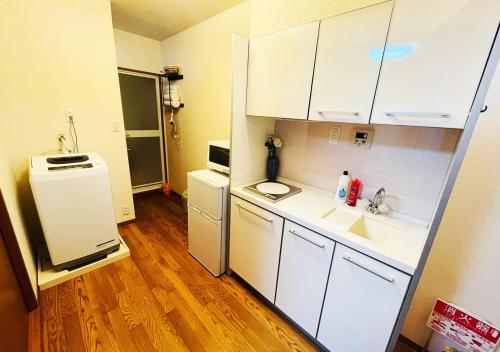 a small kitchen with a sink and a refrigerator at Yokohama Ivy 101 - 横浜 アイビー清水ヶ丘101 - in Yokohama