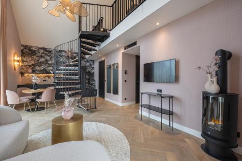 een woonkamer met een open haard en een trap bij Van der Valk hotel Den Haag Wassenaar in Wassenaar