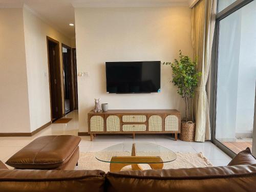 uma sala de estar com um sofá e uma televisão na parede em Vinhomes Landmark Apartment - CirillaHome em Cidade de Ho Chi Minh