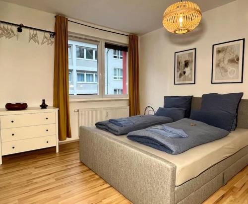 Un dormitorio con una cama con almohadas azules y una ventana en Ruhig & Zentral - 2 Kingsize Betten - Wi-Fi, en Essen