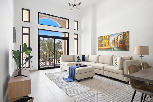 ein Wohnzimmer mit einem Sofa und einem Tisch in der Unterkunft Stylish 1BR Apt Umm Suqeim 3 in Dubai