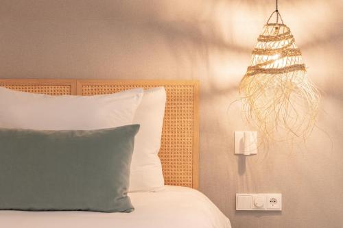 a bedroom with a bed with a pillow and a lamp at Van der Valk hotel Den Haag Wassenaar in Wassenaar