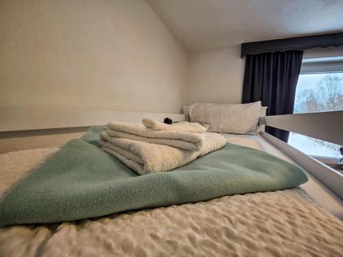 a bed with a pile of towels on it at Gruppenhaus Alpenglück in Kirchdorf in Tirol