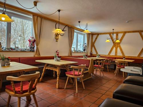 ein Restaurant mit Tischen, Stühlen und Fenstern in der Unterkunft Gruppenhaus Alpenglück in Kirchdorf in Tirol