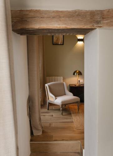 a living room with a chair and a desk at Moulin Renaudiots - Maison d'hôtes in Autun